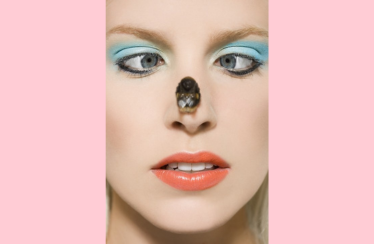 a close-up of a woman with a bee on her nose